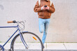 © Oscar - Courier person checking smartphone resting on city wall