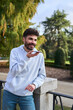 © Oscar - Young man sending voice message smartphone in park