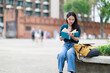© Tj - Young Asian female student engrossed in reading a book outdoors, reflecting dedication to education, learning, and knowledge at a university campus