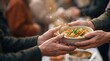© kitti - hands handing over a warm bowl of vegetable soup to another person, accented by glowing sparkling particles symbolizing charity and kindness.