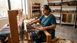 © Nurhayati - Artisan woman weaving traditional colorful textile on wooden loom.
