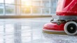 © dmmarychev - Red floor scrubber machine cleaning polished surface in bright hall