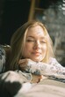 © Anastasia - Happy blonde woman enjoying warm sunlight with closed eyes, peaceful morning moment on 35mm film