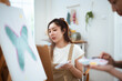 © DG PhotoStock - Two Asian women painting watercolor together in art studio at home