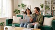 © 5 Grace Media - Happy couple sitting on a sofa and shopping online with a credit card and laptop at home.