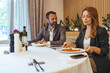 © Dragana Gordic - Business Lunch Meeting Between Colleagues in a Modern Restaurant Discussing Work Over Meals