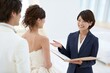 © Jumpei - 結婚式相談で笑顔の日本人カップルとウェディングプランナーが打ち合わせ