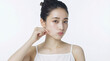 © sizzle - 自分の頬を指でつまんで肌の弾力を確かめる日本人女性