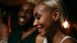 © Bussakon - Two people smiling warmly during a social gathering under warm ambient lighting  captured from a side profile perspective