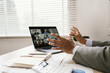 © Natthawadee - Business professional attending a virtual team meeting on a tablet while holding coffee, illustrating remote work, online collaboration, and productivity.