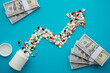 © pla2na - Flat lay growth pill medicine chart and US dollar bill banknotes on blue background. Medical expense rise, healthcare, cost of living increase, inflation crisis, financial planning and so on concept.