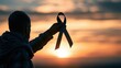 © Generative AI - Silhouette of person holding awareness ribbon against sunset, symbolizing hope and support for a cause