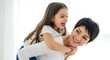 © Color Zoo - Happy mother giving a fun piggyback ride to her joyful little daughter laughing and playing together