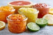 © whitestorm - Assortment of colorful citrus jams in glass jars with fresh fruits like lemons, limes, and grapefruit.