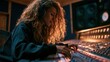 © Alina - Young woman with curly hair wearing headphones works at a sound mixing board