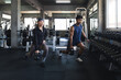 © Supachai - Asian man and woman lifting kettlebell weight inside fitness gym, athletic friends squatting exercise training session strength building workout health lifestyle