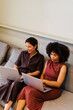 © BONNINSTUDIO/Stocksy - Businesswomen on laptops on a comfortable couch