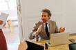 © BONNINSTUDIO/Stocksy - Business professional leading meeting discussing new strategies