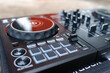 © Kornkanok - professional DJ controller with illuminated jog wheel, performance pads, mixer faders, audio controls. Modern music production, live performance, nightclub entertainment, electronic sound technology