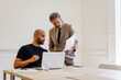 © BONNINSTUDIO/Stocksy - Business associates collaborating on laptop during meeting