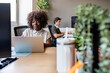 © Nunez Image SL/Stocksy - Black woman developer coding on laptop in modern office