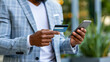 © Nataliya - Faceless businessman using a smartphone and credit card to shop online, e-commerce store, digital retail convenience, with copy space