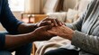 © Masque - Black man holding hands with a senior Caucasian woman to offer comfort and support.