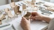 © Masque - Designer sketching a product plan and chair prototype in a furniture design studio.