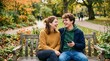 © MDSABUJ - Two young adults laugh together on a wooden park bench while sharing earbuds and a smartphone, suited for friendship, music streaming, and autumn lifestyle campaigns.