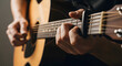 © MobiWall - Close-up of a talented musician playing an acoustic guitar with a black capo on the fretboard, hands strumming strings and holding chords, professional music performance and artistic hobby concept.