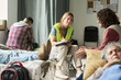 © pressmaster - Wide shot of Caucasian young adult woman counselor taking notes while supporting adults in temporary shelter, representing crisis care and outreach. For nonprofit campaigns and social services