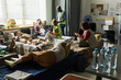 © pressmaster - Wide shot of diverse adults resting on cots while aid workers checking needs in temporary shelter, showing crisis support and relief services. For nonprofit outreach or emergency response campaigns