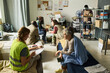 © pressmaster - Wide shot of diverse adults receiving shelter support while volunteer registering senior woman in temporary housing center. Ideal for homelessness aid, refugee relief, social care campaigns
