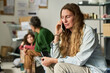 © pressmaster - Caucasian young adult woman speaking on smartphone while waiting with family in relief center, conveying crisis support and uncertainty. Useful for aid outreach or emergency response campaigns