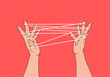 © fStop - Cat's cradle - crisscross string between two hands on bright red background