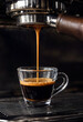 © DesignArt - Closeup of freshly brewed espresso coffee pouring into a clear glass cup from machine