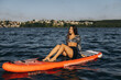 © Roman - Woman enjoying paddleboarding on calm summer lake