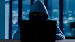 © Yassine - Mysterious masked hacker in hoodie using laptop at night, cyber criminal committing data theft, digital security breach concept