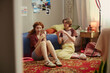 © DragonImages - Young girls creating beauty content on smartphones in bedroom, applying makeup and filming tutorial for social media. Useful for influencer marketing, youth digital lifestyle campaigns