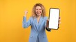 © Ben photography Ai - Confident businesswoman holding big smartphone mockup of blank screen and smiling on yellow color background.