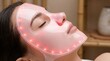 © SnapSpark Studios - Woman relaxing while wearing a glowing pink led facial light therapy mask for skin rejuvenation