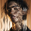 © Artfinity - Close up portrait of a curly haired woman looking through ribbed glass. Light refraction and distortion concept. Female model face with golden water caustics shadows and light play.