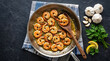 © designartwork28 - Garlic butter shrimp sautéed in a stainless-steel pan with fresh parsley and lemon slices, with garlic bulbs on a dark textured background.