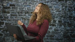 © Krakenimages.com - Woman holding laptop with left hand and right hand raised in a loose fist while smiling in studio; confidence success optimism.