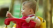 © Marco - Adorable baby infant on playground swing happy