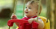 © Marco - Adorable baby infant on playground swing happy