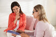 © New Africa - Life coach in glasses with clipboard consulting smiling woman on sofa in office