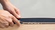 © Ammar Malik - Craftsman's hands meticulously trimming skateboard grip tape, a close-up of woodworking and board customization, DIY skate deck construction, and repair process