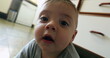 © Marco - Baby infant at kitchen floor wanting to touch camera playing
