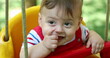 © Marco - Closeup of smiling happy baby infant boy at playground park swing